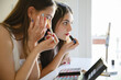 © Michela Ravasio/Stocksy - Two girls friends putting on makeup together