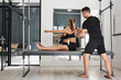 © Nicola Suttle/Stocksy - Personal trainer helping sportswoman during pilates workout