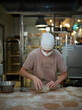 © Miquel Llonch/Stocksy - Baker kneading the dough in the workshop