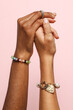 © Anna Tabakova/Stocksy - Two female hands with jewelry on holding each other