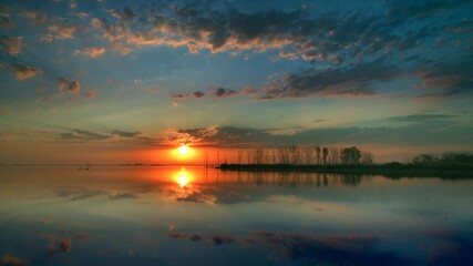 Wall Mural - Tranquil wilderness time lapse, still waters reflecting moving clouds, sunrise sky.

