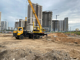 Wall Mural - Workers engineers working at construction site and cranes on background of new building skyscrapers