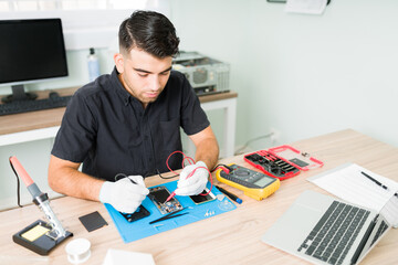 Wall Mural - Young man measuring the voltage of a smartphone