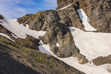 Wall Mural - rocky volcanic mountain with exposed rock and patches of snow.