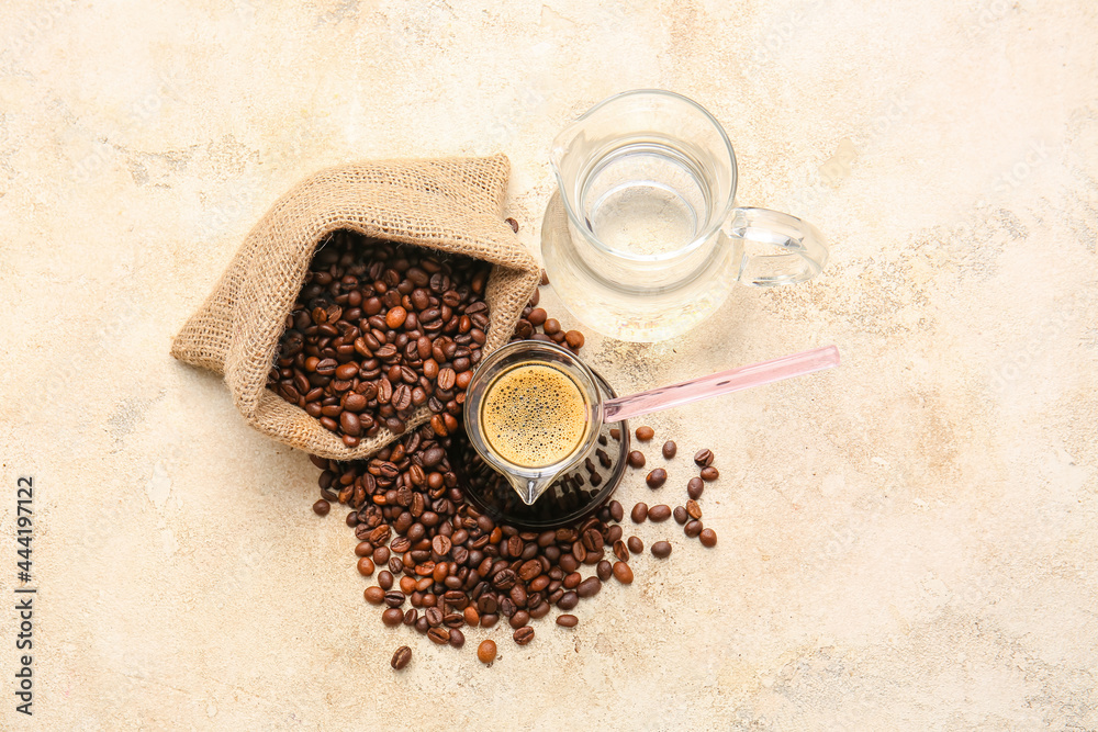 Turkish coffee in cezve and beans on grunge background