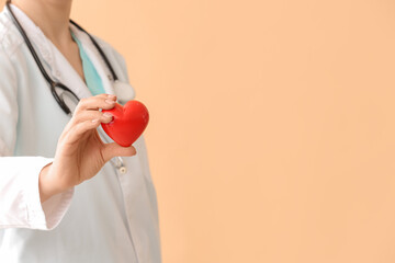 Wall Mural - Female cardiologist with red heart on color background