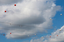 Electric Wires With Multi-colored Balls Attached To Them Against The Background Of The Sky