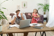 © skif - father works at home with a laptop together with his daughter. a little girl wants to play the guitar, make noise. sad man tries to work while working remotely at home
