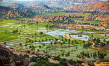 Fototapeta Natura - Rocky mountain with paddy field shot is taken at Anjeyanadri Hill hampi karnataka india.