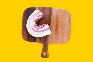 Streaky pork in white plate on yellow background.