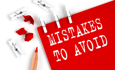 Poster - MISTAKES TO AVOID text on red paper with office tools on white background