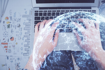 Double exposure of man's hands typing over computer keyboard and social network theme hologram drawing. Top view. People connection web concept.