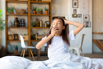 A ten-year-old girl woke up, stretching and yawning.