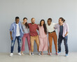 © Studio Romantic - Studio group portrait of cheerful diverse millennial friends standing together. Happy young people in different comfortable casual wear huddling, laughing and having fun. Clothes and fashion concept