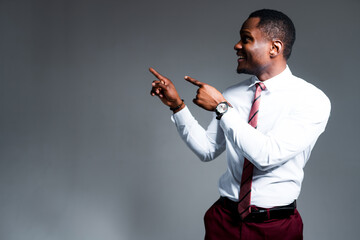 Happy african american man in white shirt smiling and showing with hands to the side looking there