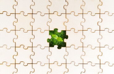 Fresh grass and young plant seen through a blank piece of a jigsaw puzzle