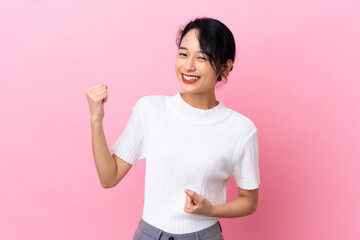 Young Vietnamese woman isolated on pink background celebrating a victory