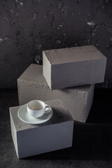 Wall Mural - Empty cup coffee on concrete grey cube as  background texture.  Abstract concept of break coffee time