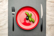 Diet. Small amount of food on the plate. One olive is in a red plate, a knife and a fork. Weight loss and diet concept. Empty space for text
