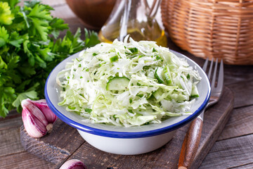 Healthy cabbage salad with cucumber, green onion and parsley on a plate