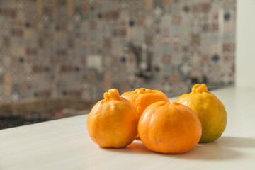 Tangerines on the Brazilian kitchen table with tile in the background and copy space. Orange citrus and tropical fruit. Fruit concept. Tangerine concept.