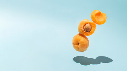 Aesthetic summer fruit idea with fresh organic apricot on bright blue background. Creative vertical composition, minimalistic sweet and healthy food idea.