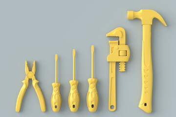 Top view of monochrome construction tools for repair on grey and yellow