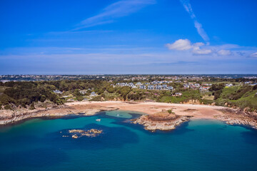 Wall Mural - Aerial Drone image of Portelet Bay, Jersey, Channel Islands with blue sky and calm water.
