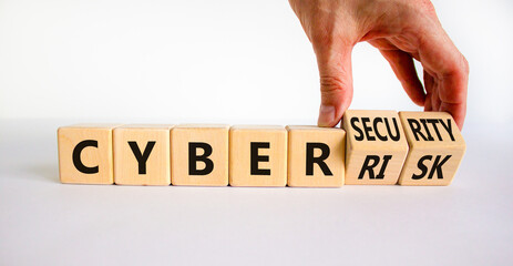 Cyber-security vs cyber-risk symbol. Businessman turns wooden cubes, changes words Cyber-risk to cyber-security. Beautiful white background. Cyber-security vs cyber-risk concept. Copy space.