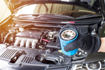 Wall Mural - Close up hand a man put oil filter for car maintenance concept in engine room