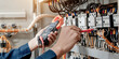 © A Stockphoto - Electrician engineer uses a multimeter to test the electrical installation and power line current in an electrical system control cabinet.