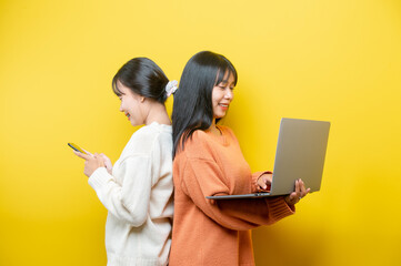 Full length body size turned photo of cheerful positive cute nice attractive blogger browsing through her laptop in search of new information isolated over yellow vibrant color background