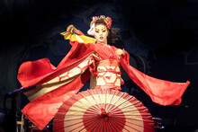 Woman Dances With A Fan And Umbrella, With Flowing Sleeves. Traditional Japanese Performance Red Fox Dance. Kino Kitsune Fox Is A Character In Japanese Legends.