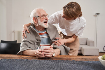 Poster - Nurse warming up with blanket her senior patient while working