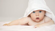 Close-up portrait of cute baby boy in white terry towel on white background. Bathing babies and restful sleep. funny   child face..