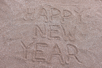 happy new year inscription on the sand. in English. new year on vacation at the sea.