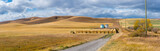 Fototapeta  - Rural Alberta Canadian prairie grassland landscape countryside background panorama. Beautiful farmer's field and grain silos with hay bales wallpaper 