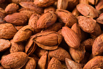 Delicious unpeeled roasted almonds nuts  background