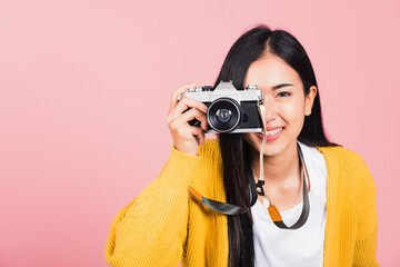 Wall Mural - woman smiling photographer taking a picture and looking viewfinder on retro vintage photo camera