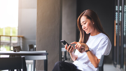 Poster - A beautiful young asian woman holding and using mobile phone