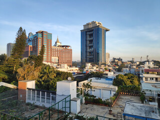 A sunlit view of rooftops and buildings in downtown Bangalore, India on a clear sunny day