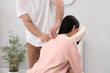 © New Africa - Woman receiving massage in modern chair indoors