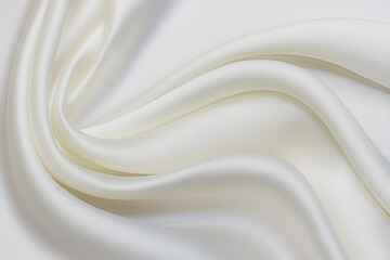 milky-colored silk fabric in artistic layout. texture, background, pattern.