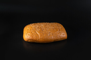 panini bun with sesame, sandwich. Without ingredients, on a black background. Bakery production concept.