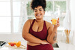 © (JLco) Julia Amaral - Body positive woman drinking fruit juice at home