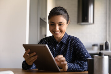 Poster - Happy Indian woman with tablet using app on computer for video call, shopping online, reading message and getting good news. Student watching webinar. Customer satisfied with Internet service work