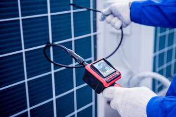 the technician uses a digital camera to check the clogging of the heat exchanger