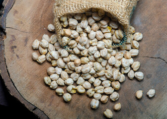 Wall Mural - Chickpeas in wooden plank on dark background.