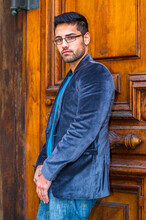 Dressing In A Dark Blue Woolen Blazer And Jeans, Wearing Glasses, A Young Scholar With A Little Bread And Mustache Is Standing In The Front Of Door, Thoughtfully Looking At You..