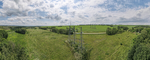 Industrial high voltage electricity tower in green field at summer, in countryside. Wide panorama 180